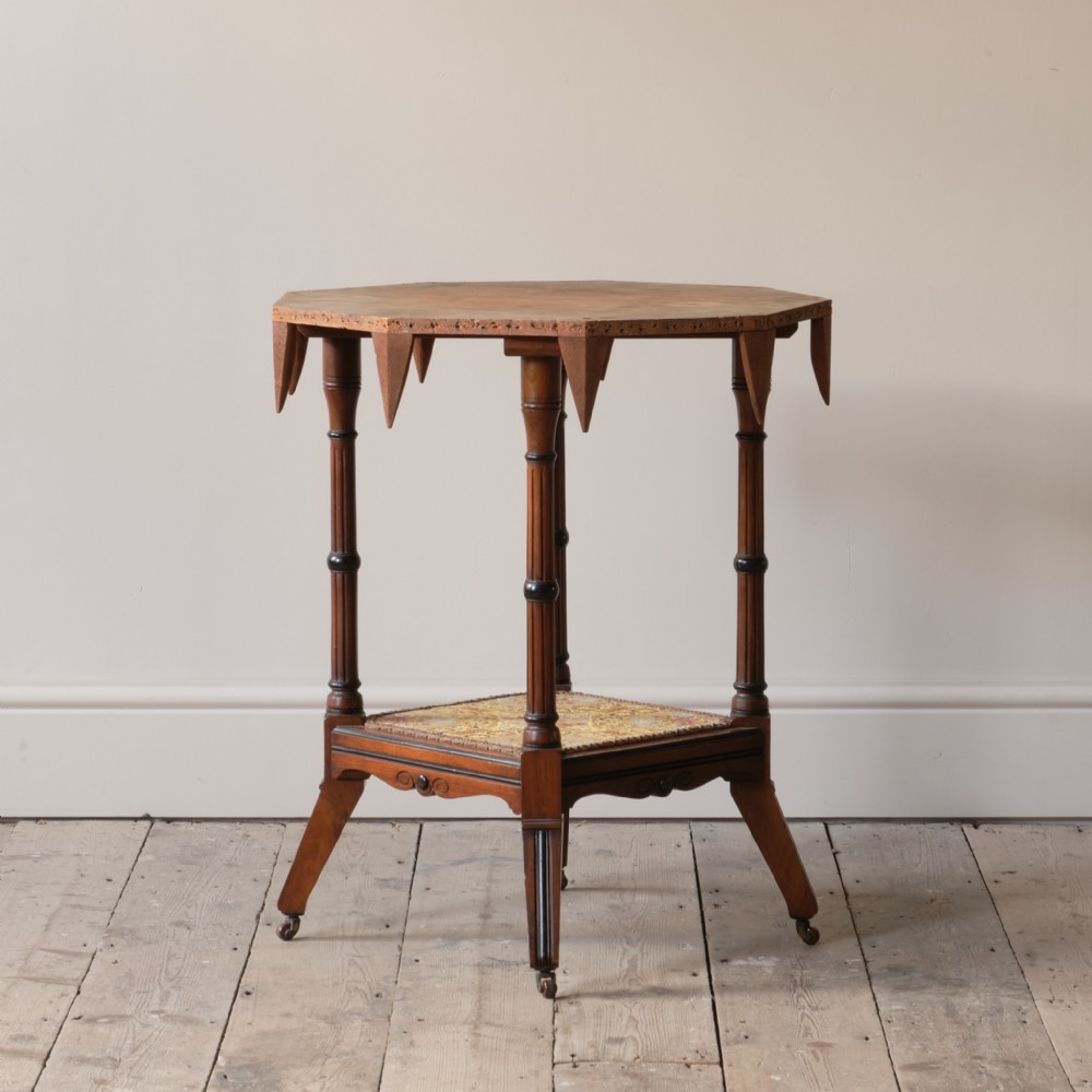 A 19th-century octagonal Aesthetic Movement side table with turned ebonised legs, a lower shelf, and a beaded tapestry top.