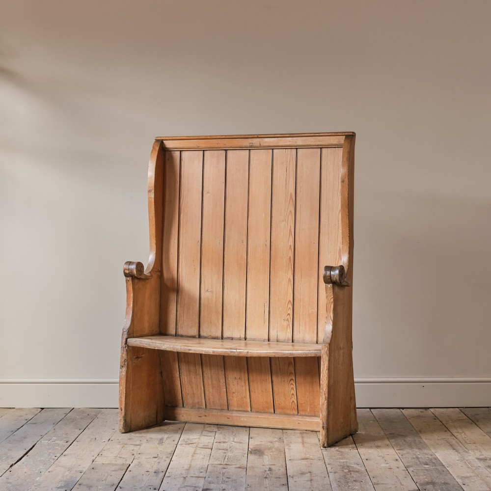 A 19th-century pine and elm high-backed settle featuring scrolled armrests and vertical plank construction. View II