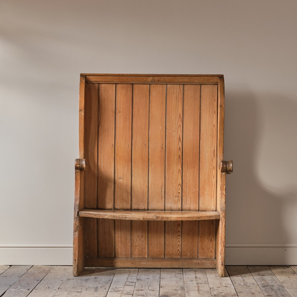 A 19th-century pine and elm high-backed settle featuring scrolled armrests and vertical plank construction. View III