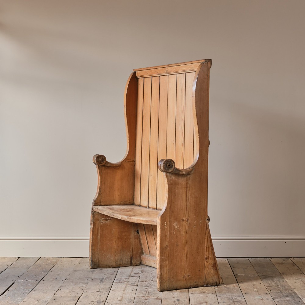 A 19th-century pine and elm high-backed settle featuring scrolled armrests and vertical plank construction. View IV