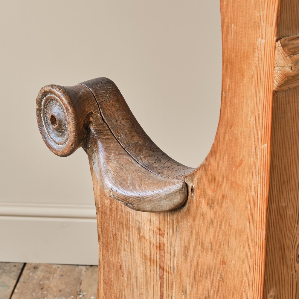 A 19th-century pine and elm high-backed settle featuring scrolled armrests and vertical plank construction. View XI