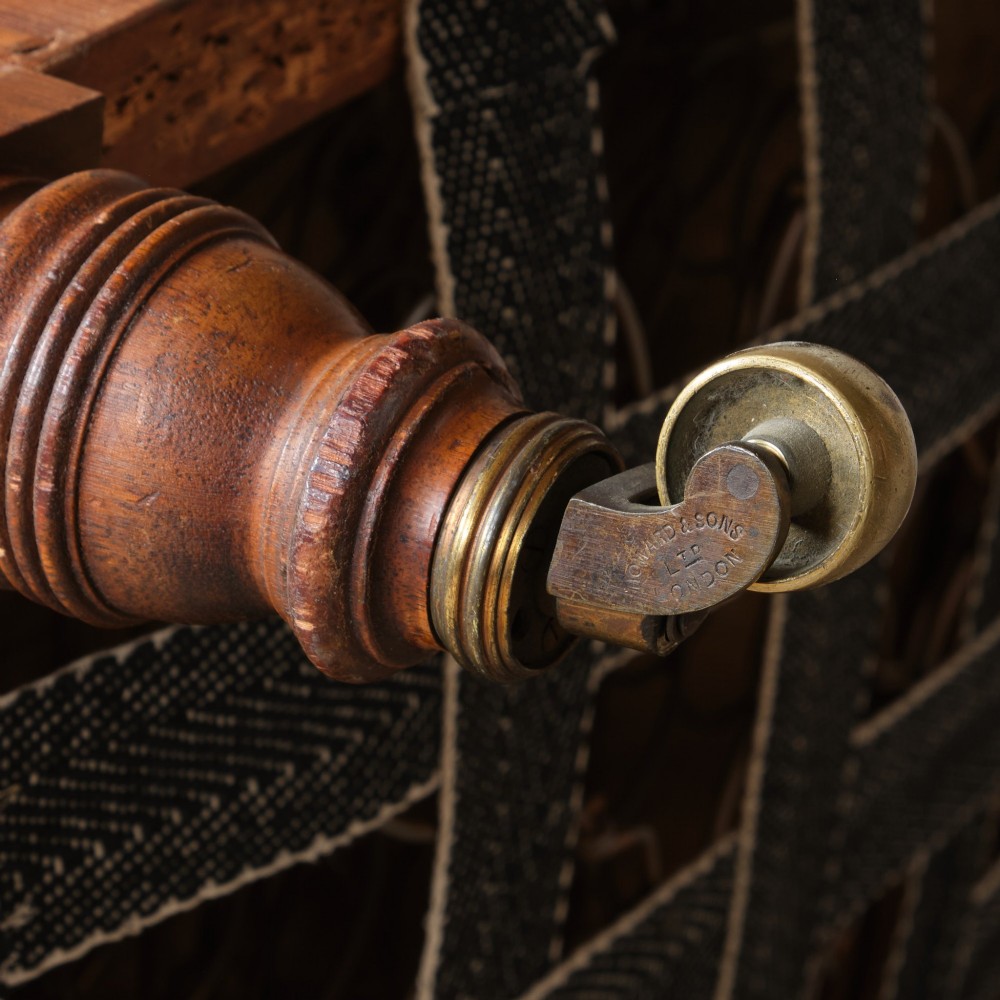 A 19th-century Howard and Sons Pickwell tub armchair showing exposed original hessian, horsehair filling, a brown velvet seat cushion, turned wooden legs, and brass castors. View XIII