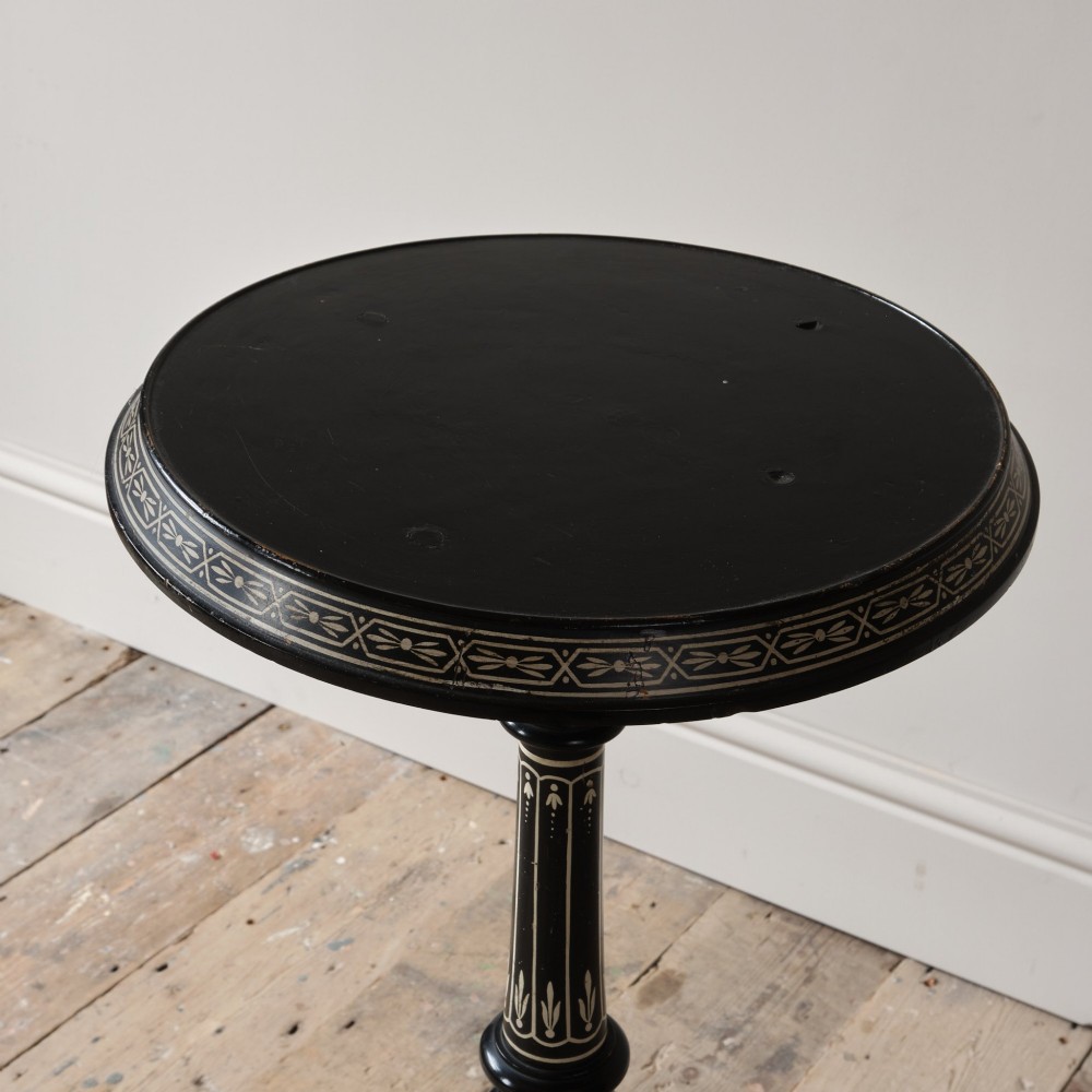 A 19th-century Aesthetic Movement ebonised tripod side table featuring a circular top, turned central column, light-coloured decorative inlay, and finial details. View VI