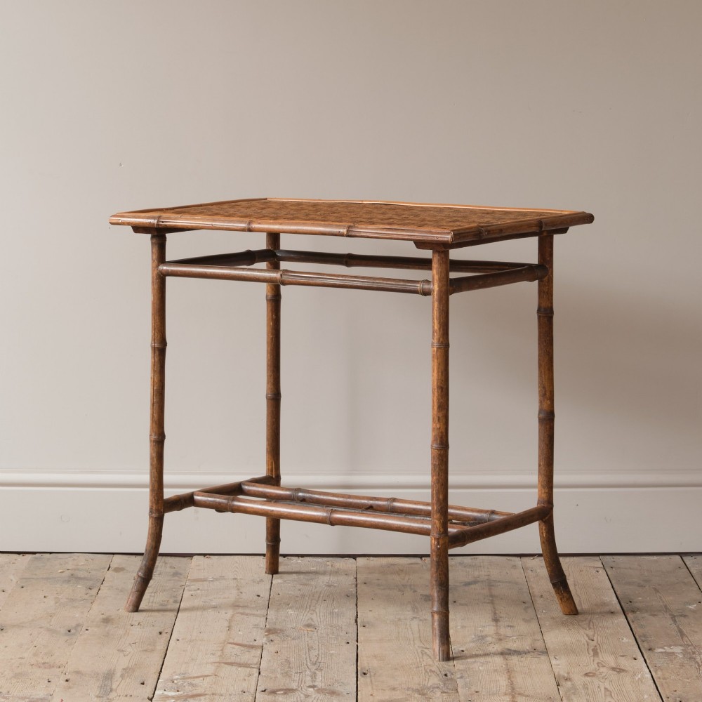 An early 20th-century bamboo side table featuring a rectangular woven cane top, bamboo legs, and lower cross stretchers. View II