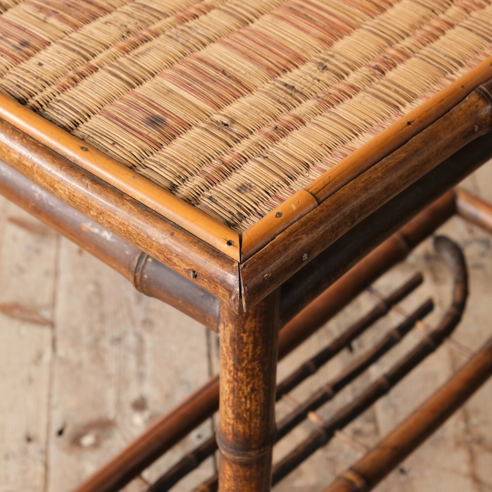 An early 20th-century bamboo side table featuring a rectangular woven cane top, bamboo legs, and lower cross stretchers. View V