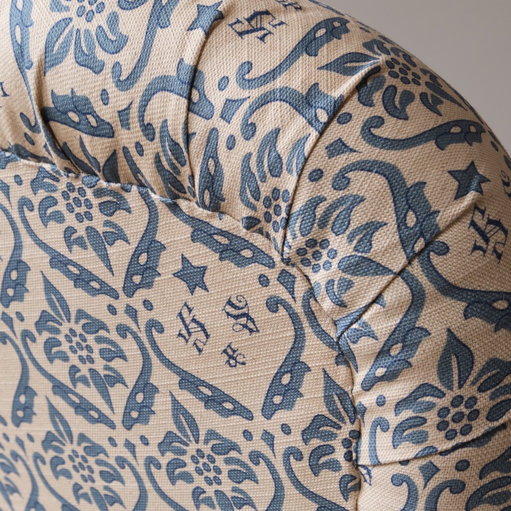 A mid-19th century Victorian upholstered armchair featuring blue and cream patterned fabric, deep button-tufted backrest, turned wooden front legs, and brass castors. View IX