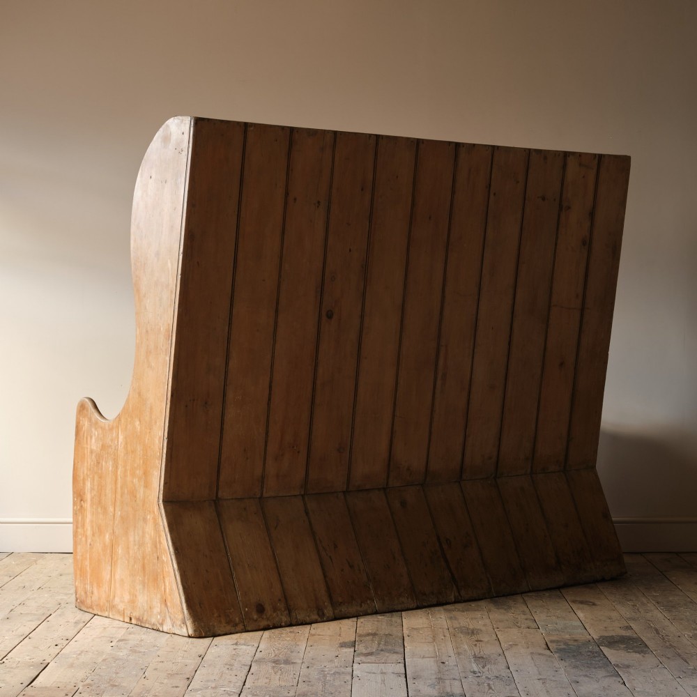 An early nineteenth-century Georgian pine high-backed settle featuring winged side panels and a planked box base. View VII