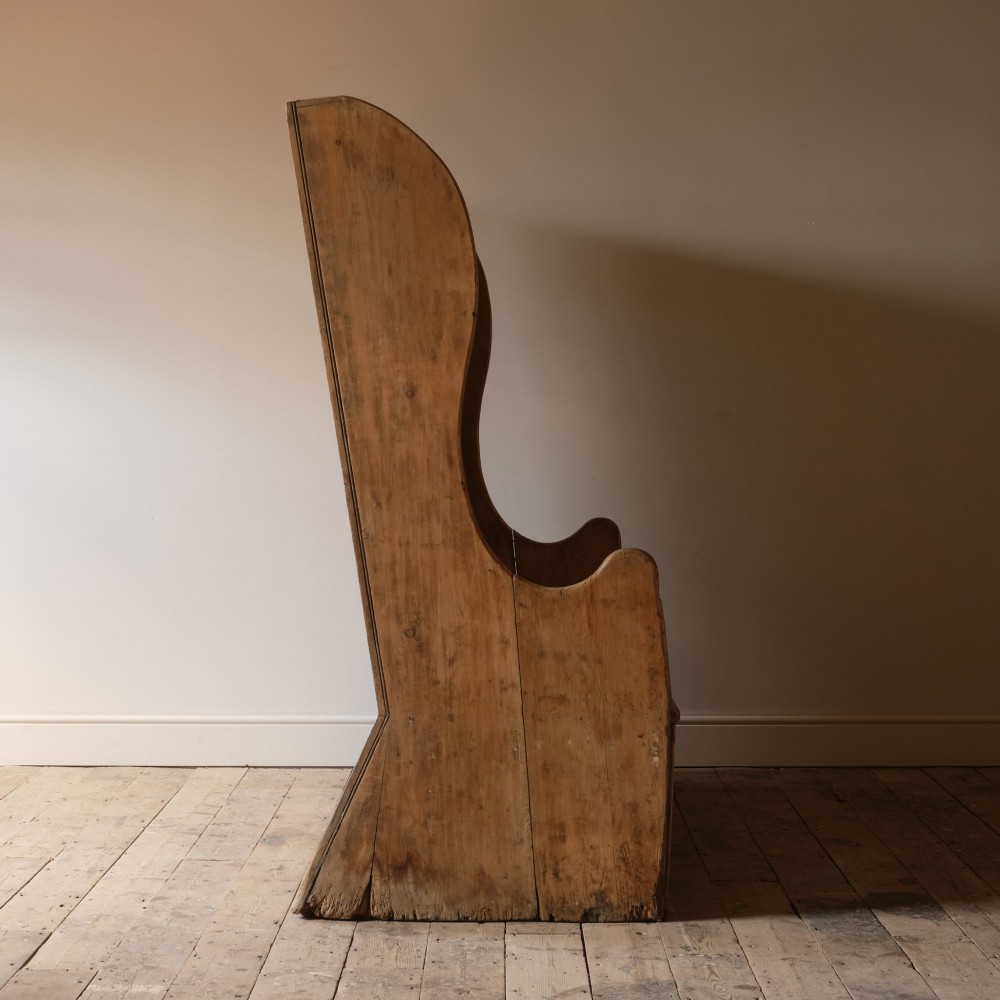 An early nineteenth-century Georgian pine high-backed settle featuring winged side panels and a planked box base. View XIV