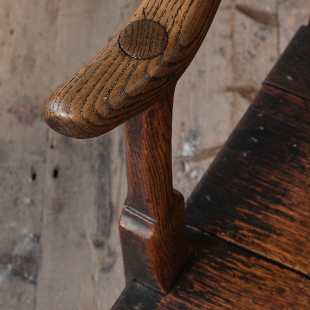 A Georgian oak open armchair featuring a vase-shaped splat back, solid seat, shaped armrests, and an H-stretcher base. View III