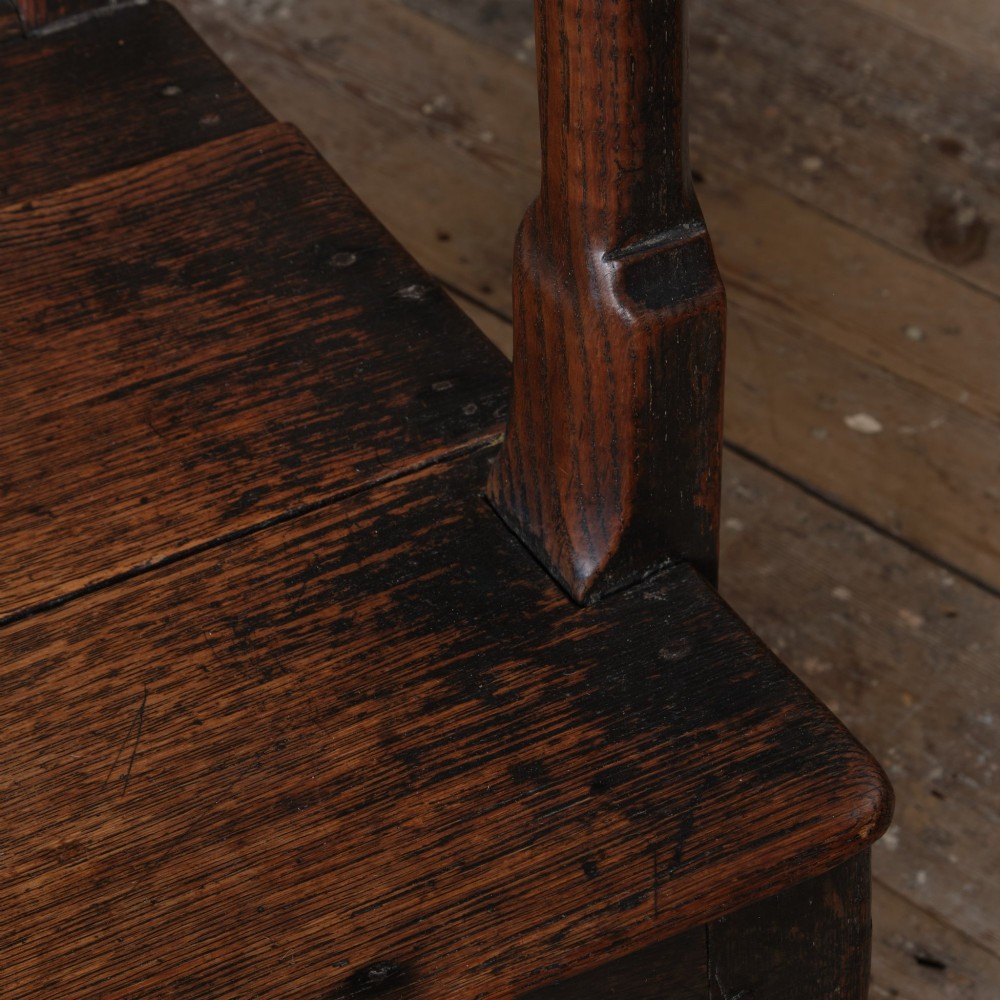 A Georgian oak open armchair featuring a vase-shaped splat back, solid seat, shaped armrests, and an H-stretcher base. View V