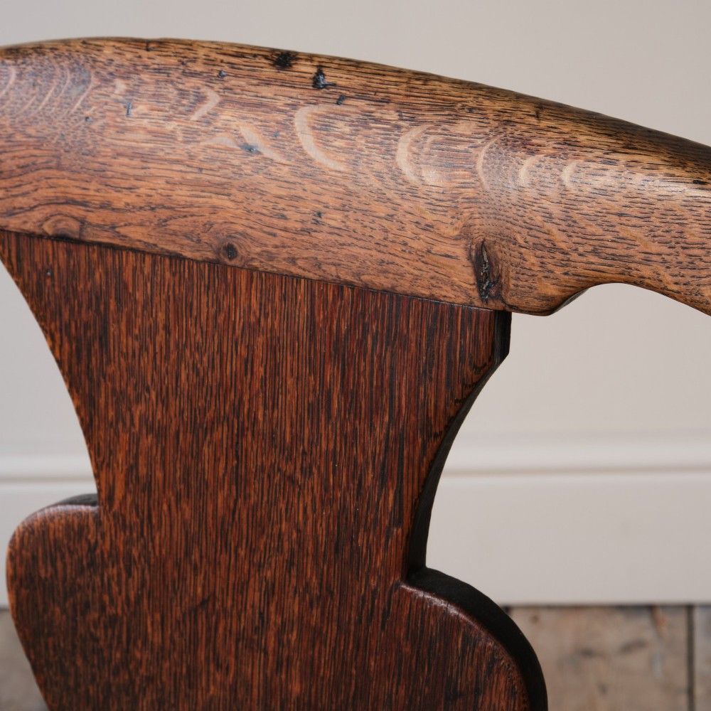 A Georgian oak open armchair featuring a vase-shaped splat back, solid seat, shaped armrests, and an H-stretcher base. View VIII