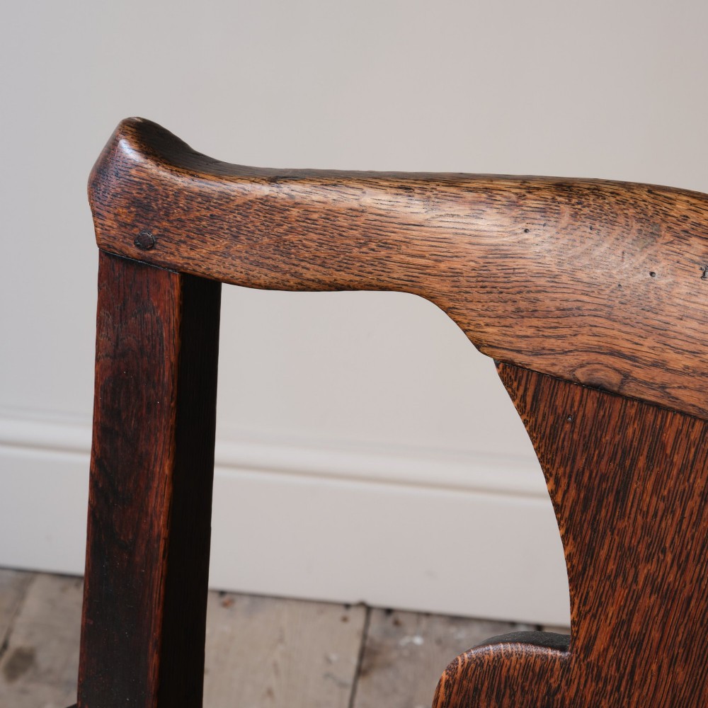 A Georgian oak open armchair featuring a vase-shaped splat back, solid seat, shaped armrests, and an H-stretcher base. View XI