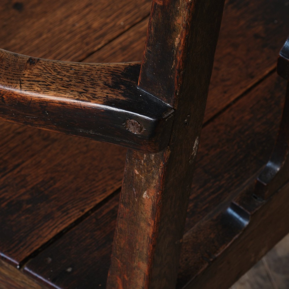 A Georgian oak open armchair featuring a vase-shaped splat back, solid seat, shaped armrests, and an H-stretcher base. View XII