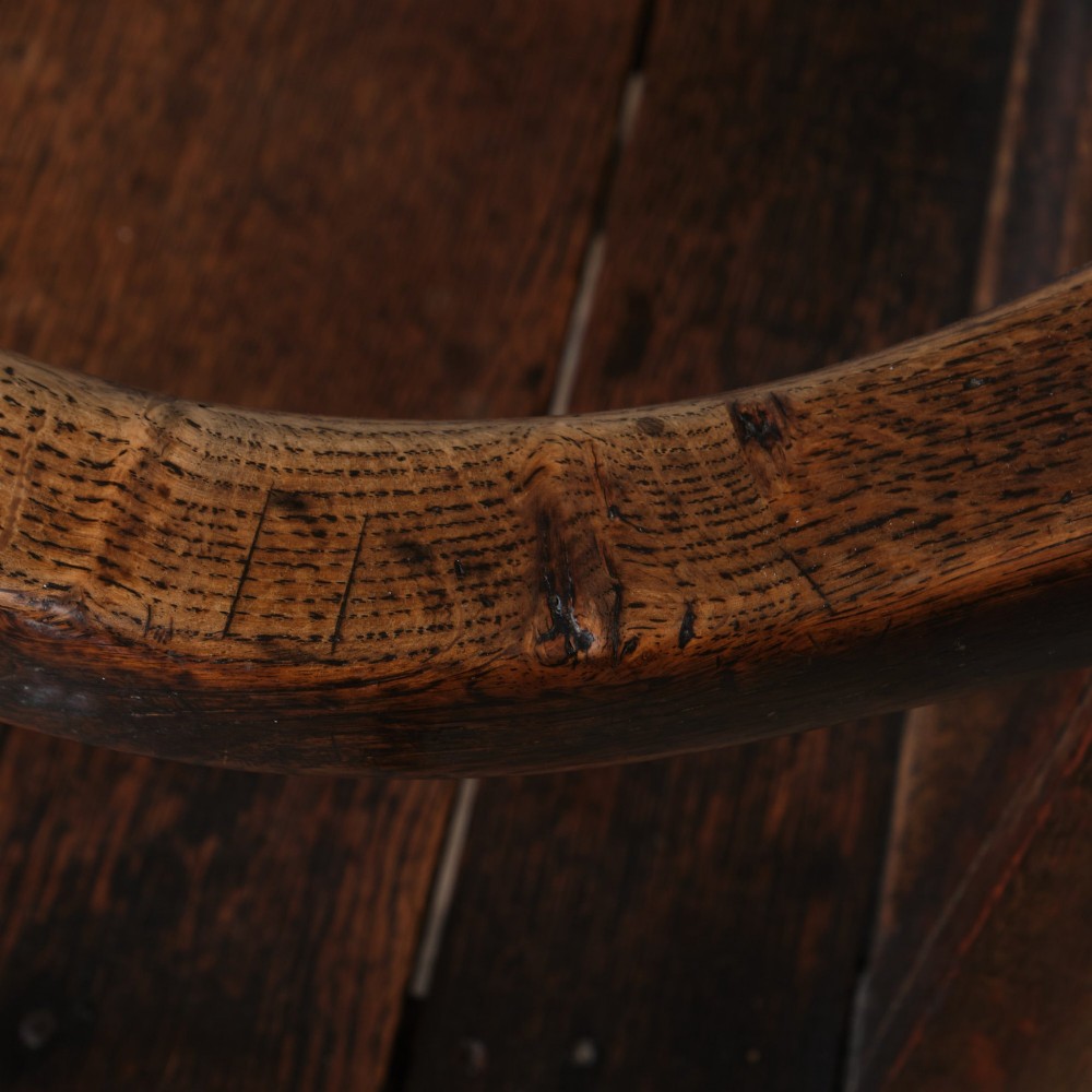 A Georgian oak open armchair featuring a vase-shaped splat back, solid seat, shaped armrests, and an H-stretcher base. View XIV