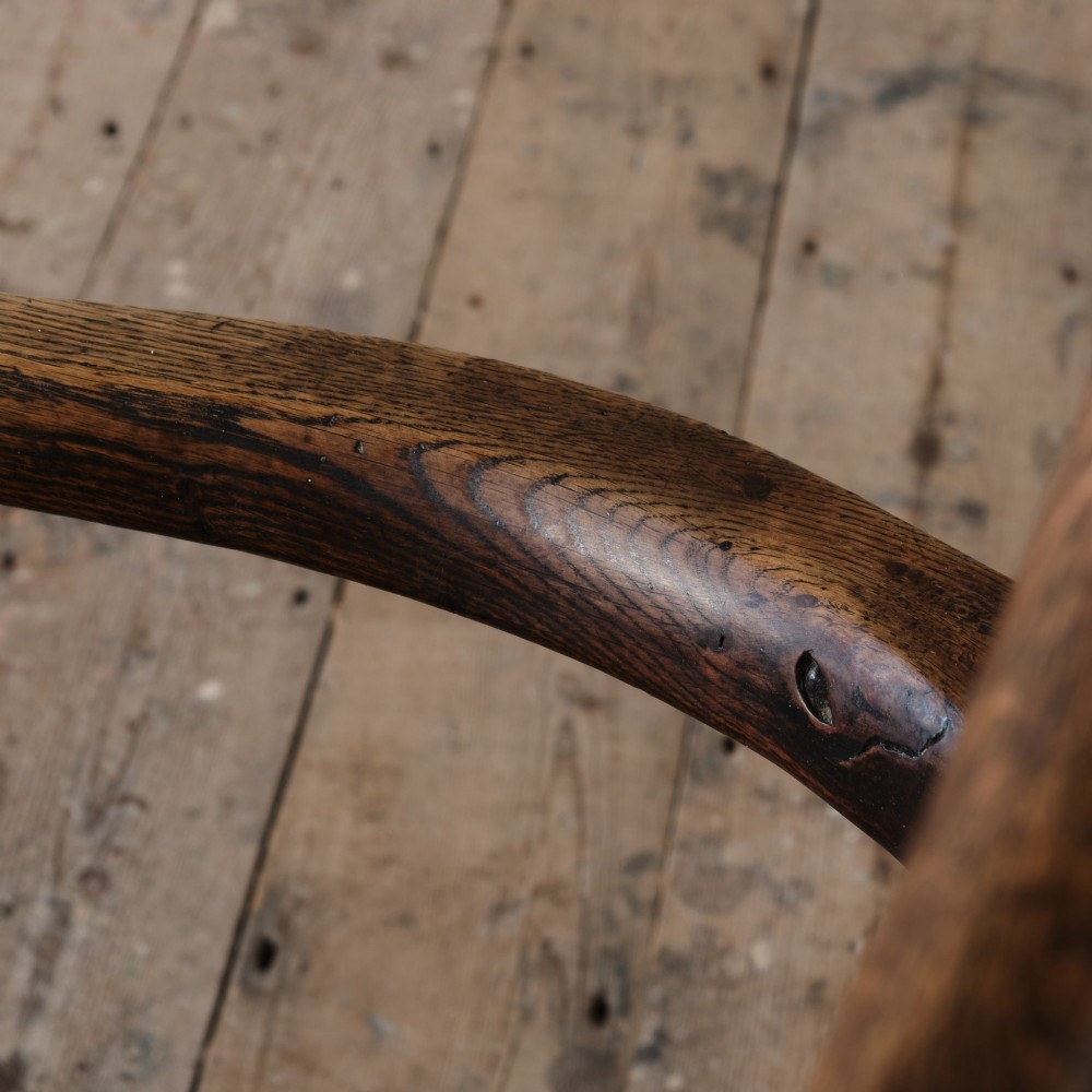 A Georgian oak open armchair featuring a vase-shaped splat back, solid seat, shaped armrests, and an H-stretcher base. View XV