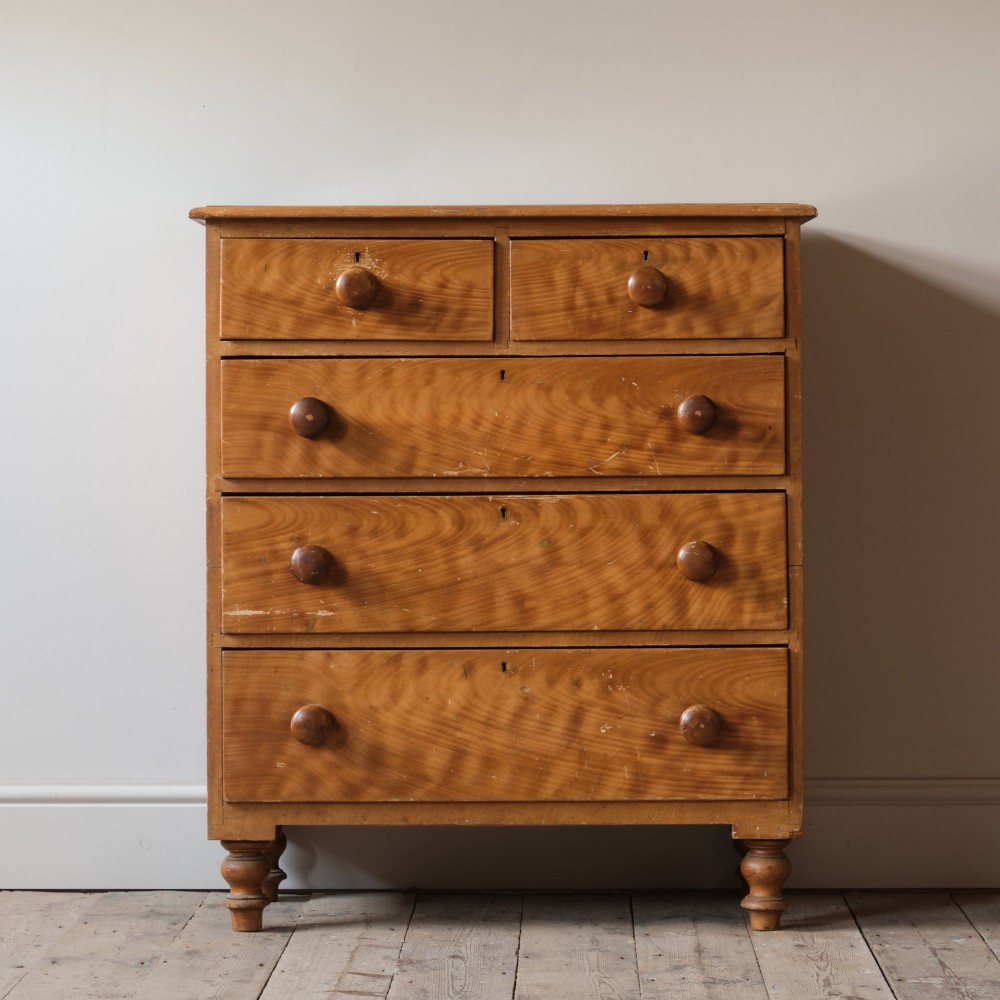 A Victorian 19th-century pine chest of drawers with a scumble painted finish, featuring two short over three long drawers with turned wooden knobs.