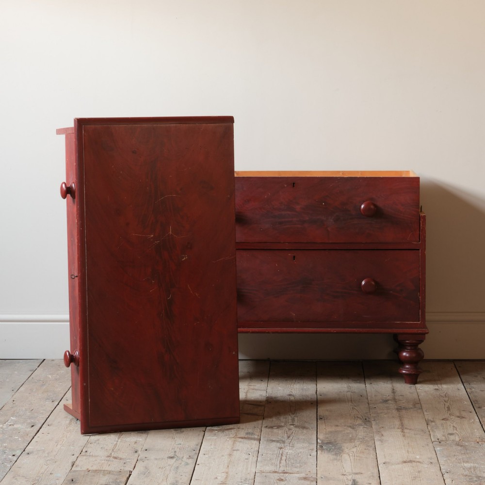 A 19th-century red painted pine chest of three drawers with wooden knob handles and turned feet. View V