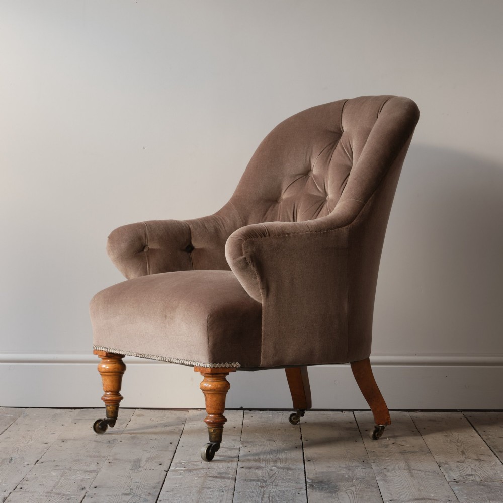 A mid-19th-century button-backed armchair upholstered in taupe velvet with turned timber front legs resting on brass castors. View III