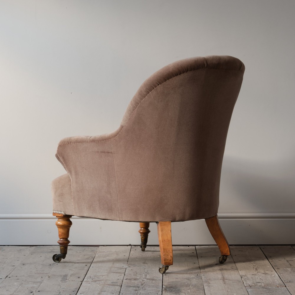A mid-19th-century button-backed armchair upholstered in taupe velvet with turned timber front legs resting on brass castors. View V