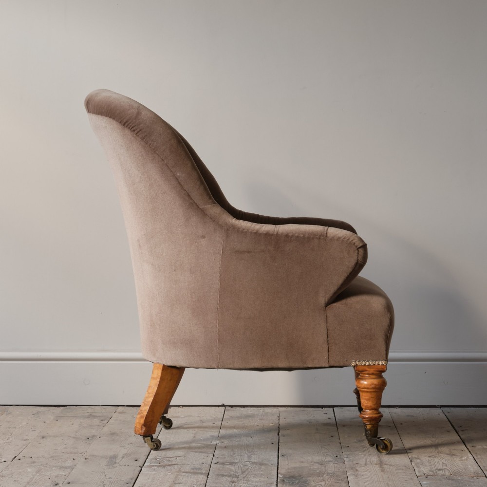 A mid-19th-century button-backed armchair upholstered in taupe velvet with turned timber front legs resting on brass castors. View VII