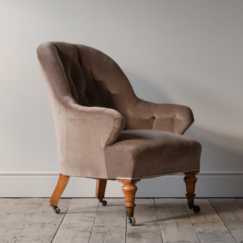 A mid-19th-century button-backed armchair upholstered in taupe velvet with turned timber front legs resting on brass castors. View VIII