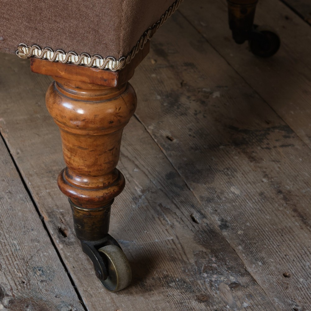 A mid-19th-century button-backed armchair upholstered in taupe velvet with turned timber front legs resting on brass castors. View IX