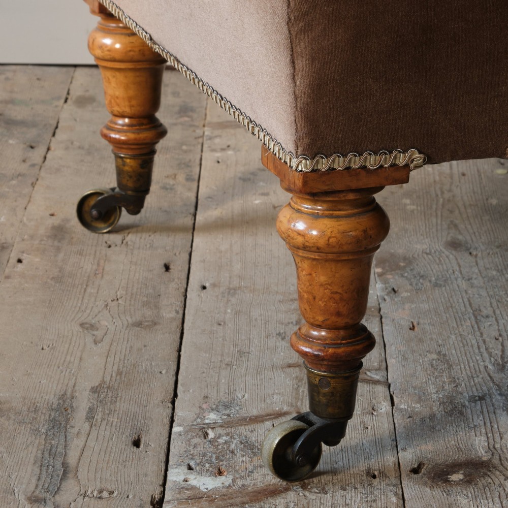 A mid-19th-century button-backed armchair upholstered in taupe velvet with turned timber front legs resting on brass castors. View X