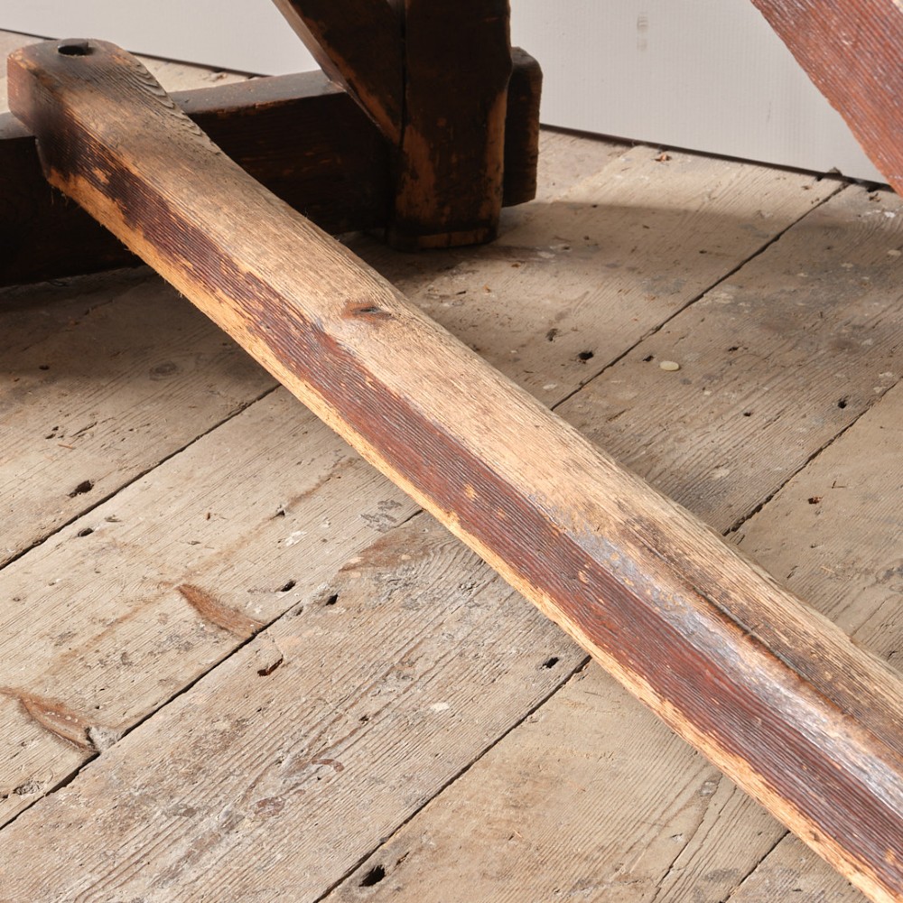A long antique pine workbench table featuring a heavy plank top supported by a sturdy timber frame with X-frame cross bracing. View XIII