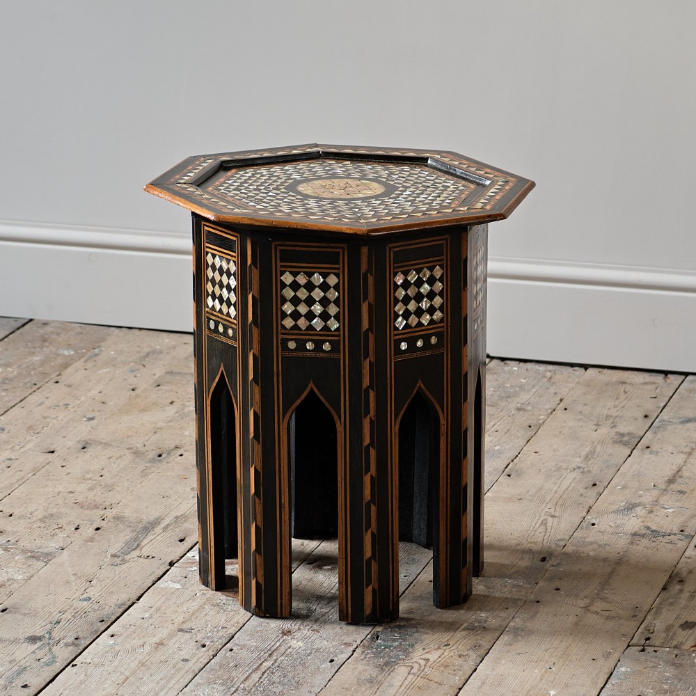 An octagonal dark ebonised wood Moorish side table featuring geometric mother-of-pearl inlay and pointed arch cut-outs along the base.