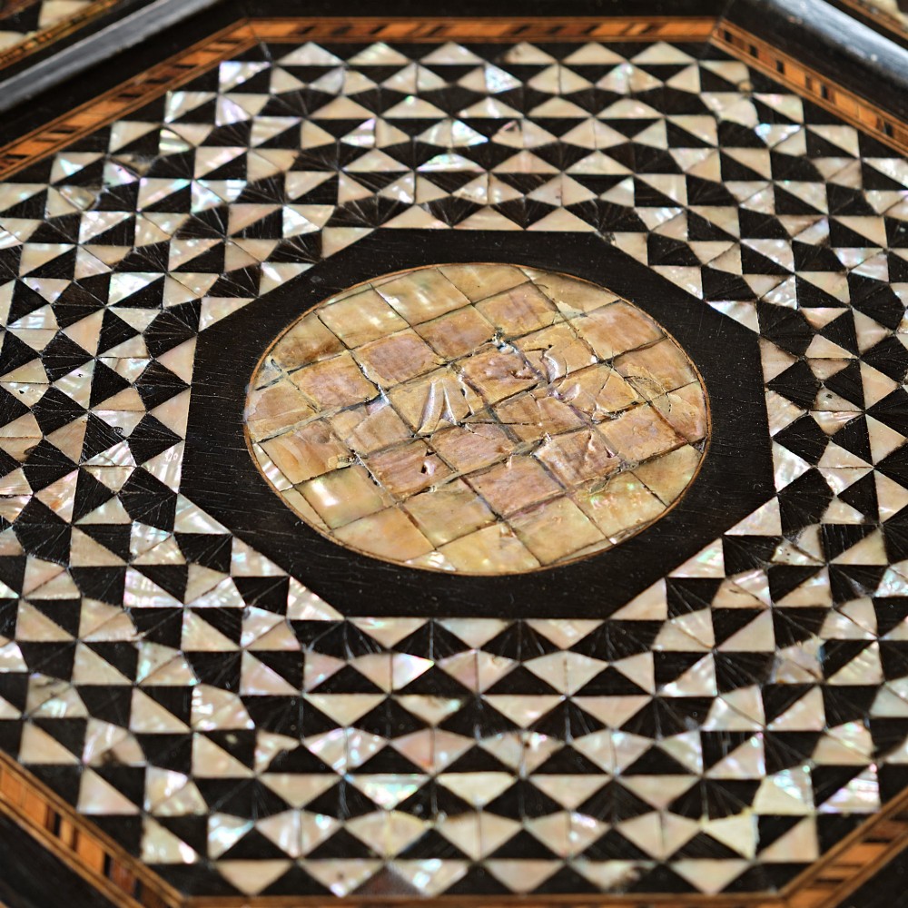 An octagonal dark ebonised wood Moorish side table featuring geometric mother-of-pearl inlay and pointed arch cut-outs along the base. View V