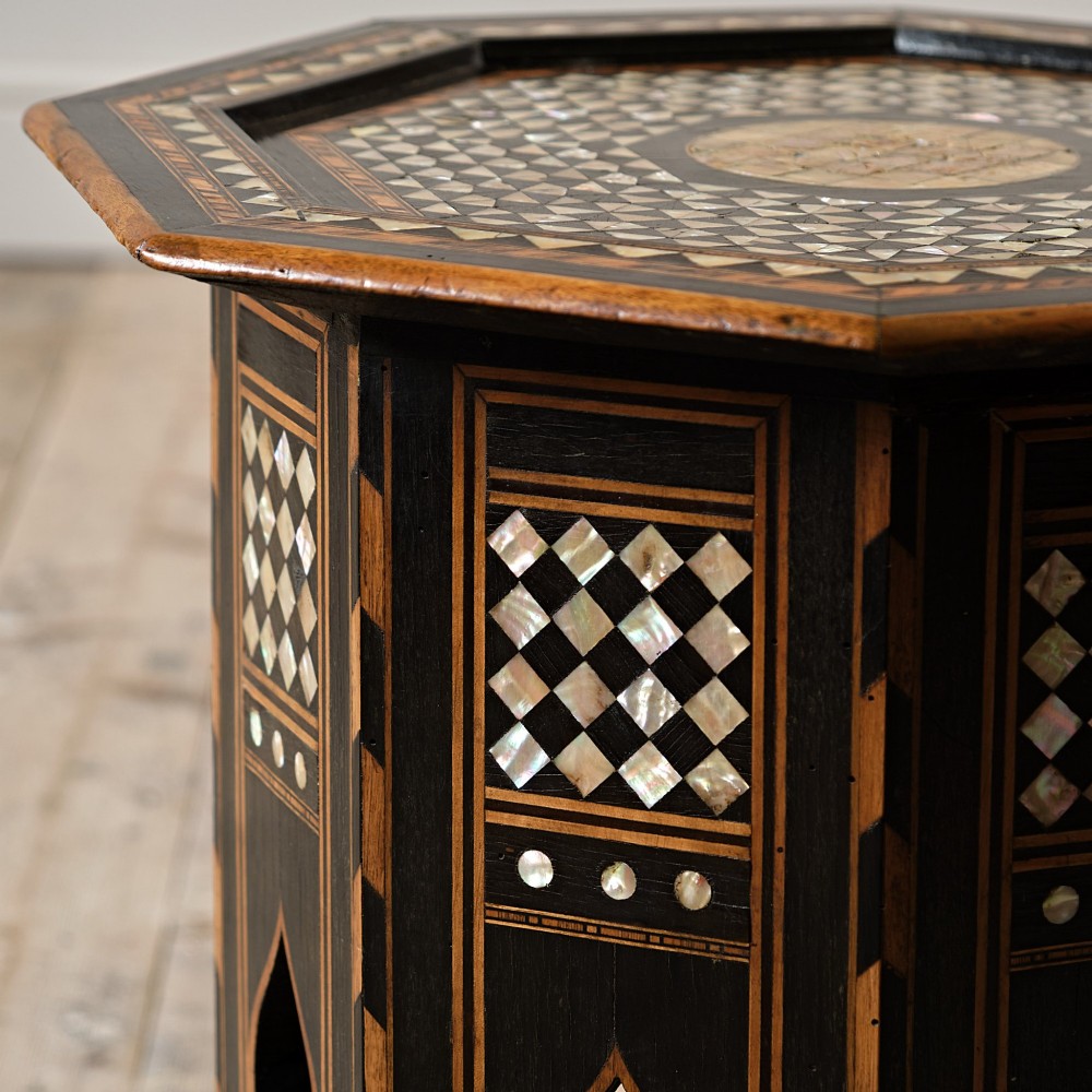 An octagonal dark ebonised wood Moorish side table featuring geometric mother-of-pearl inlay and pointed arch cut-outs along the base. View VIII