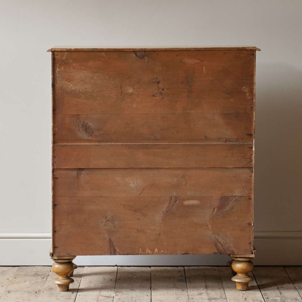 A mid-nineteenth-century pine chest of drawers featuring a faux-grain painted finish, turned wooden knobs, two short drawers over three long drawers, and turned feet. View IV