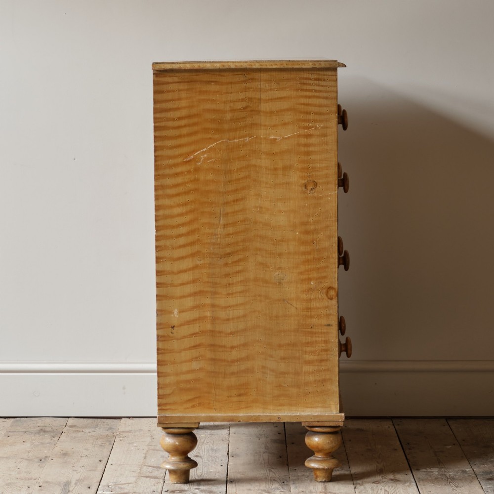 A mid-nineteenth-century pine chest of drawers featuring a faux-grain painted finish, turned wooden knobs, two short drawers over three long drawers, and turned feet. View V
