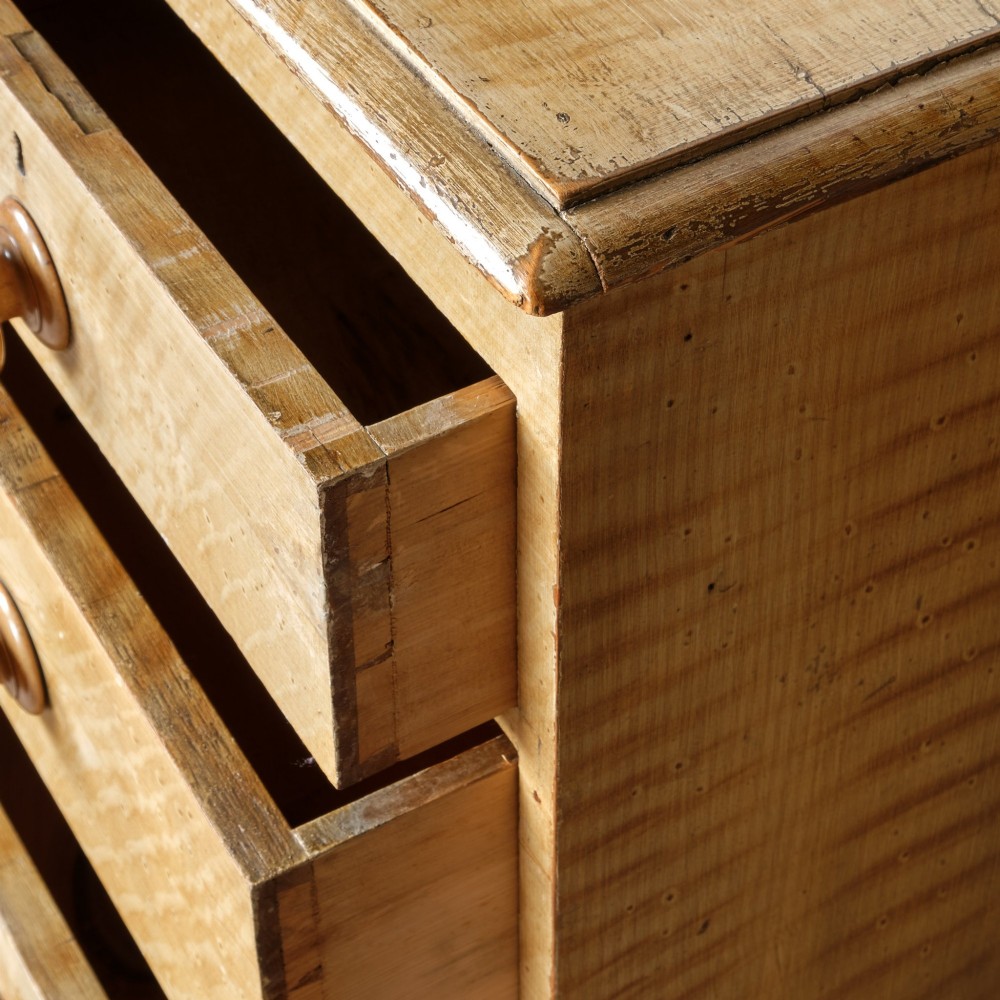 A mid-nineteenth-century pine chest of drawers featuring a faux-grain painted finish, turned wooden knobs, two short drawers over three long drawers, and turned feet. View VII