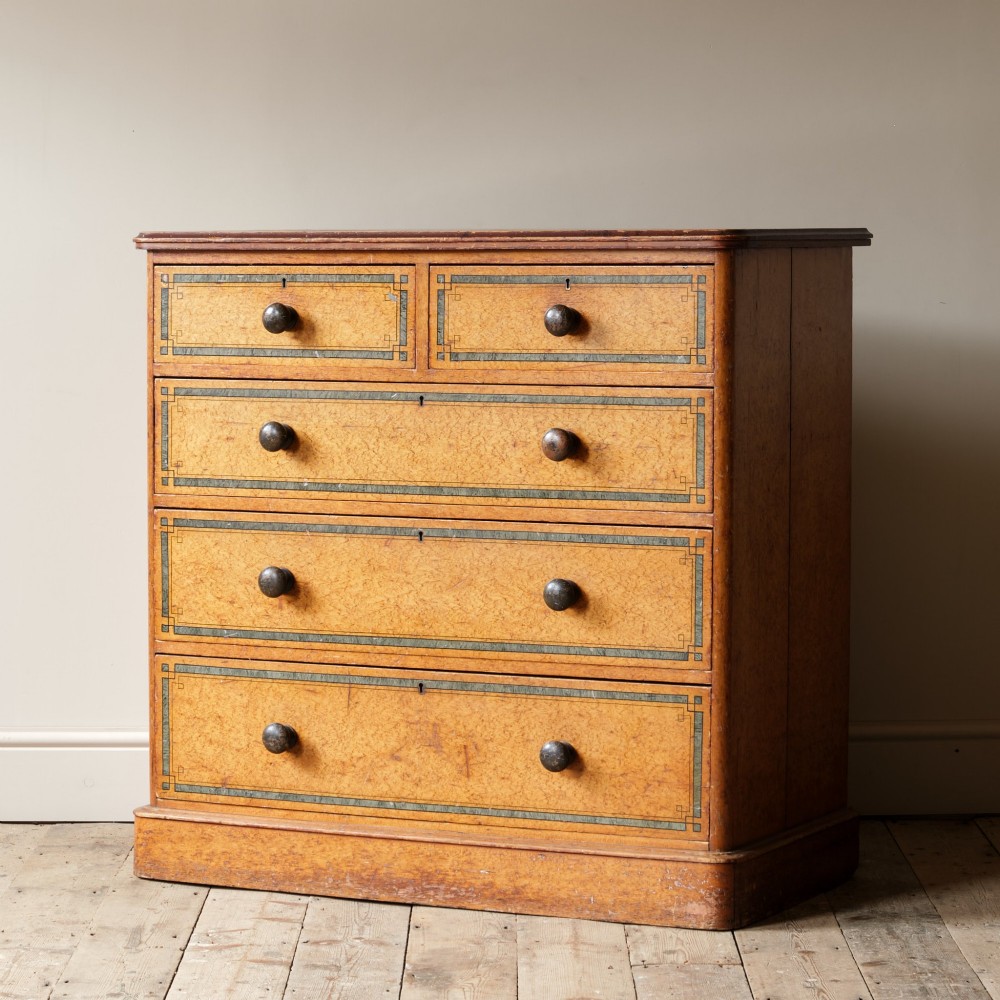 A 19th-century pine chest of drawers featuring an ochre painted finish with decorative green line borders, two short drawers over three long drawers, and turned wooden knobs. View II
