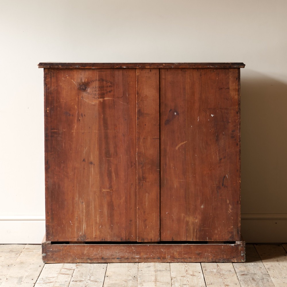 A 19th-century pine chest of drawers featuring an ochre painted finish with decorative green line borders, two short drawers over three long drawers, and turned wooden knobs. View V