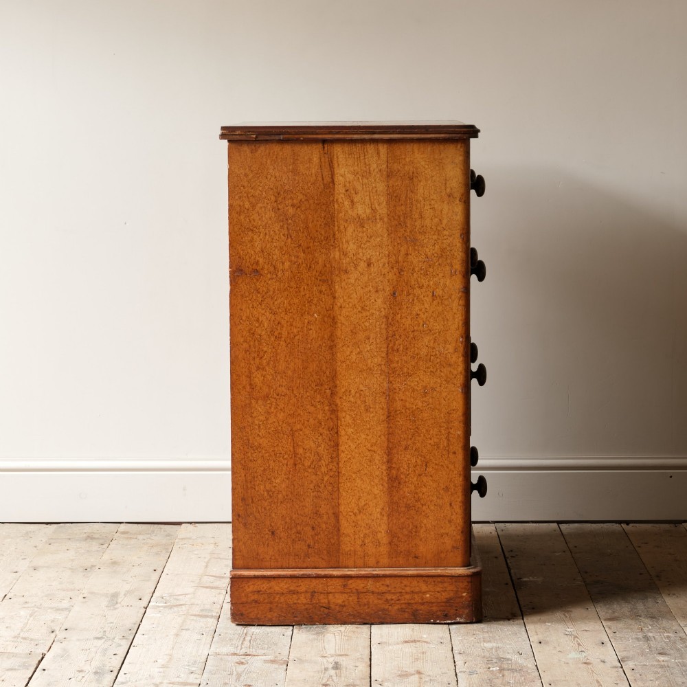 A 19th-century pine chest of drawers featuring an ochre painted finish with decorative green line borders, two short drawers over three long drawers, and turned wooden knobs. View VI