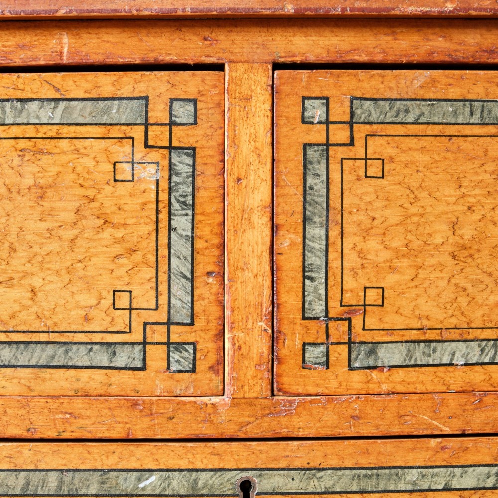 A 19th-century pine chest of drawers featuring an ochre painted finish with decorative green line borders, two short drawers over three long drawers, and turned wooden knobs. View IX