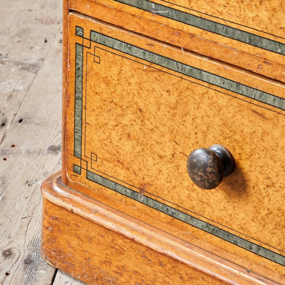 A 19th-century pine chest of drawers featuring an ochre painted finish with decorative green line borders, two short drawers over three long drawers, and turned wooden knobs. View XI