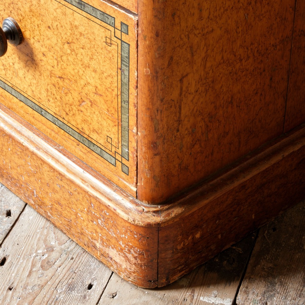 A 19th-century pine chest of drawers featuring an ochre painted finish with decorative green line borders, two short drawers over three long drawers, and turned wooden knobs. View XII