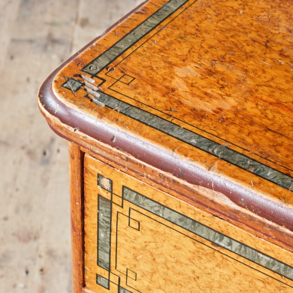 A 19th-century pine chest of drawers featuring an ochre painted finish with decorative green line borders, two short drawers over three long drawers, and turned wooden knobs. View XIV