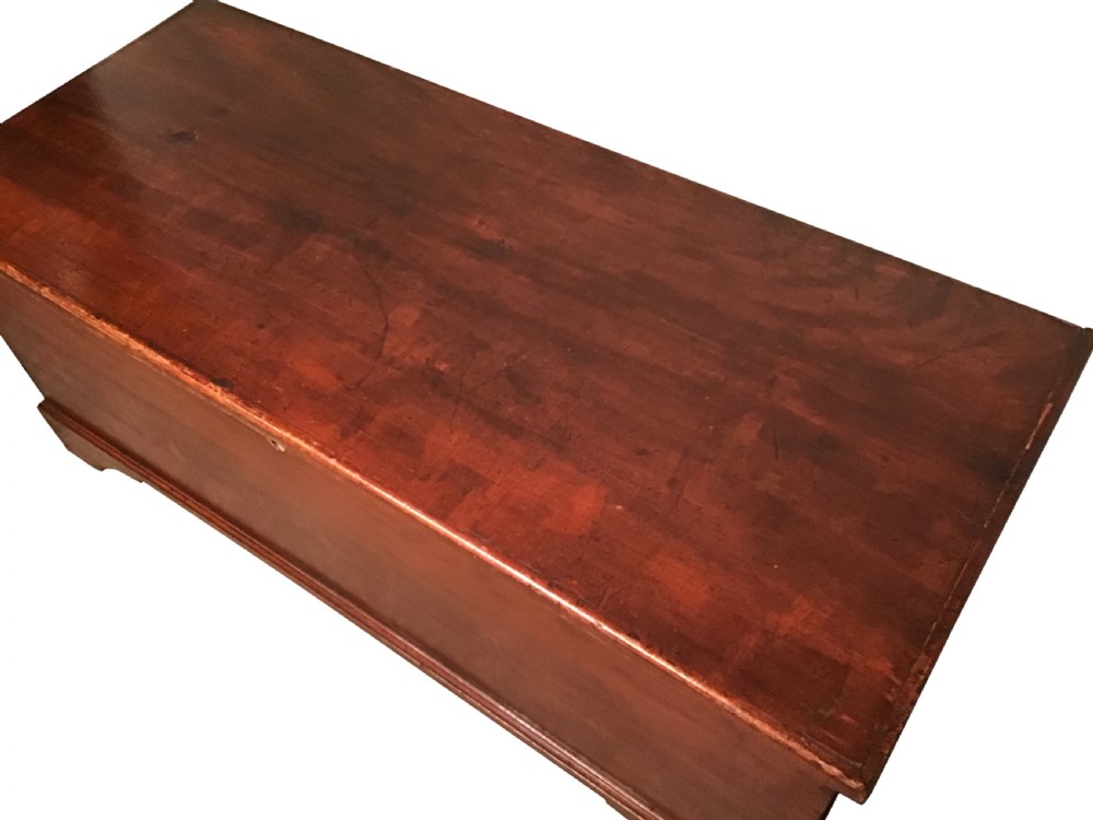 A low rectangular antique painted pine coffer featuring a hinged top lid, brass keyhole escutcheon, and bracket feet. View II
