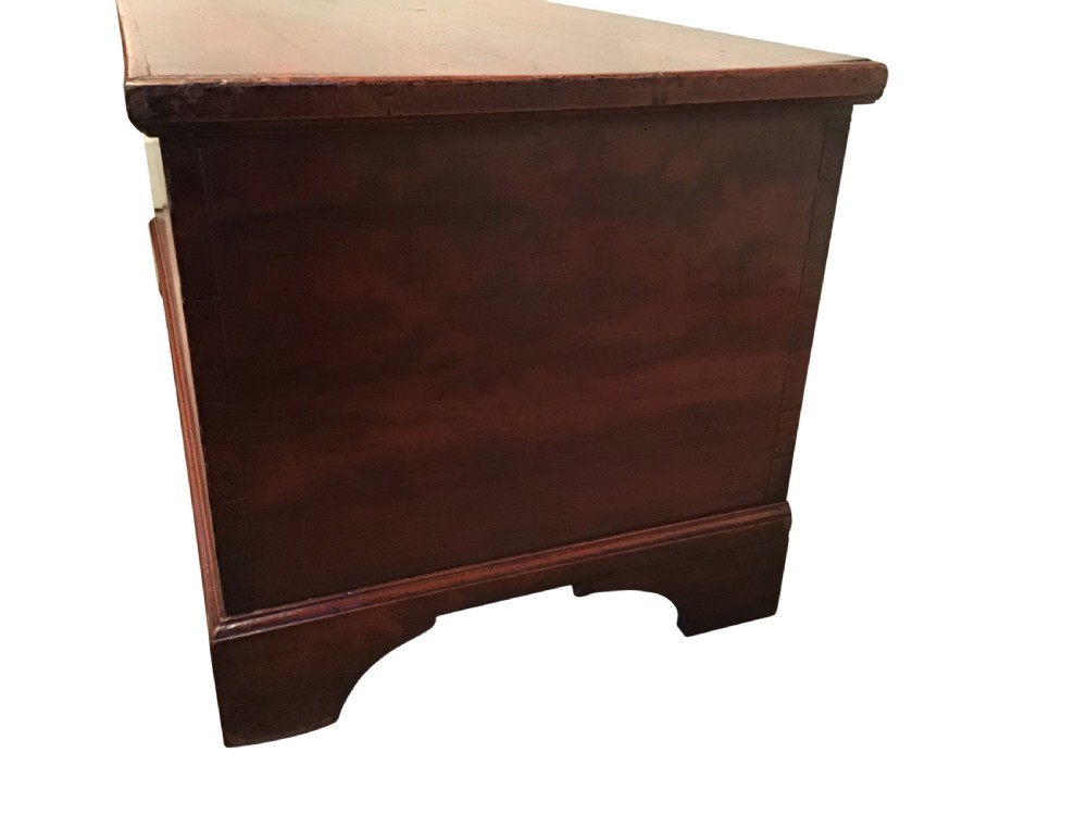 A low rectangular antique painted pine coffer featuring a hinged top lid, brass keyhole escutcheon, and bracket feet. View III
