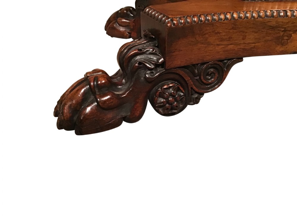 A William IV rosewood fold-over card table featuring a rectangular top with rounded corners, gadrooned edging, a central pedestal stem, and a carved quadform base resting on paw feet. View V