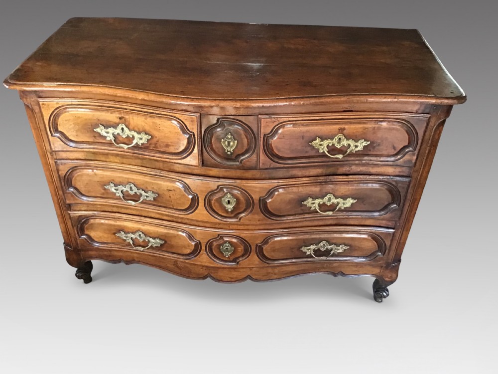 An antique French Louis XV style walnut commode featuring three contoured drawers with moulded panels and ornamental brass handles on cabriole legs. View II