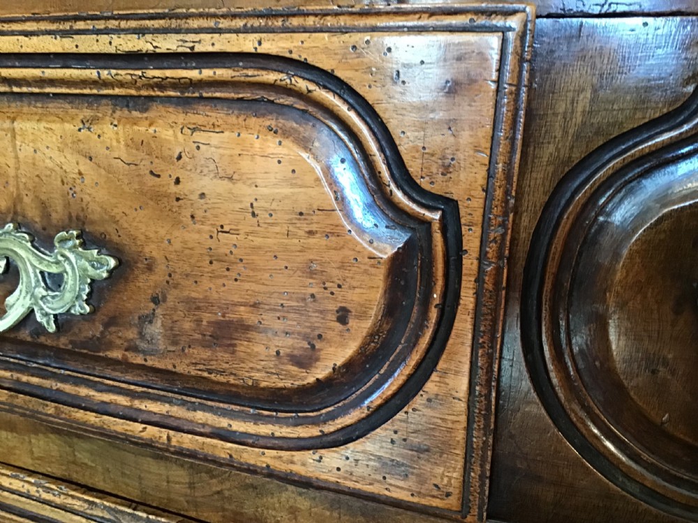 An antique French Louis XV style walnut commode featuring three contoured drawers with moulded panels and ornamental brass handles on cabriole legs. View VIII