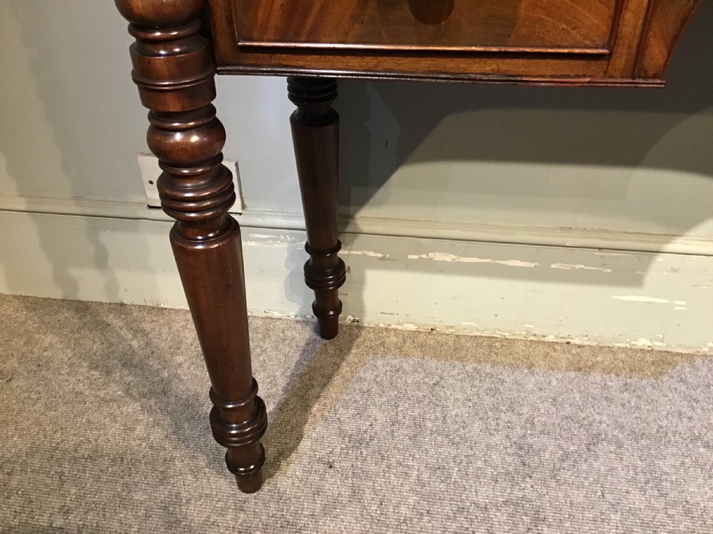 An antique mahogany hall table featuring a gallery back, five drawers with turned knobs, an arched kneehole centre, and four turned legs. View XIII