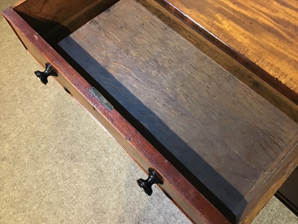 An antique mahogany hall table featuring a gallery back, five drawers with turned knobs, an arched kneehole centre, and four turned legs. View XV