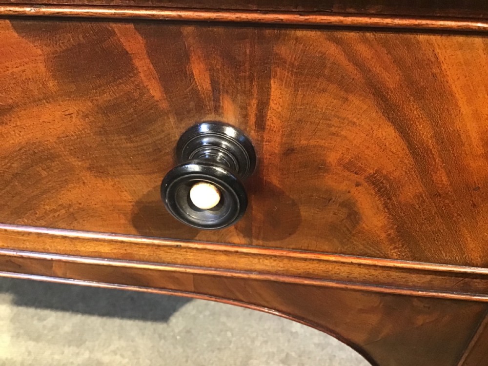 An antique mahogany hall table featuring a gallery back, five drawers with turned knobs, an arched kneehole centre, and four turned legs. View XVIII
