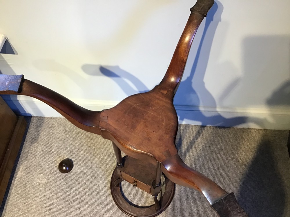 An antique Georgian mahogany tripod washstand featuring an upper basin ring, a middle triangular drawer section with an urn finial, and cabriole legs. View VIII
